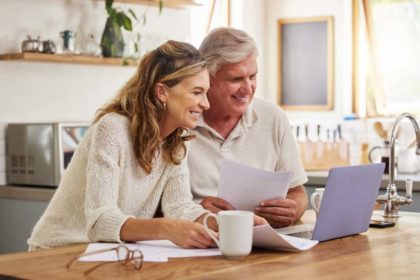 Couple on laptop with paperwork for investing in an IRA