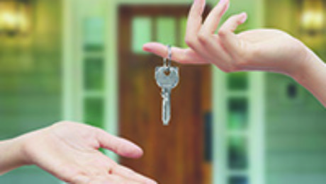 Person handing keys to new home owner